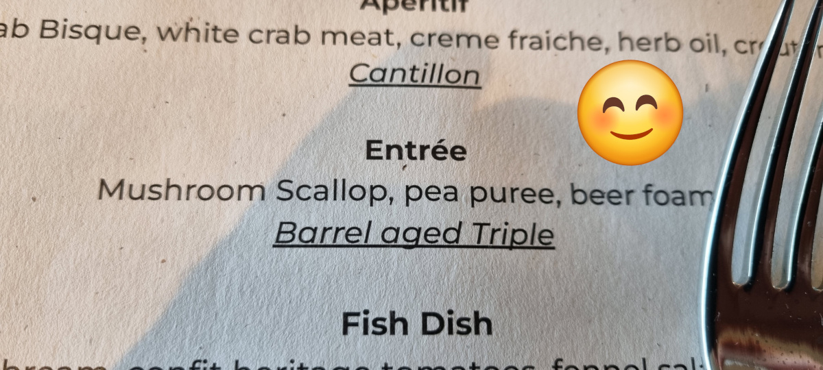 A close up of a beer tasting menu showing a pairing of a barrel aged triple beer with a mushroom scallop and pea puree.