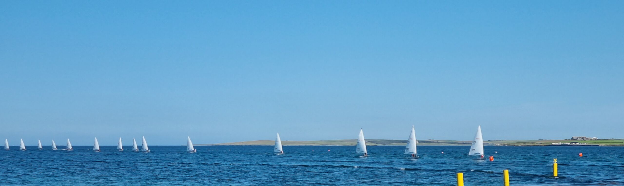 ILCAs returning to Hatston slip A long line of ILCA sailing dinghies returning to Hatston slip after a race in the Orkney 2025 Island Games.